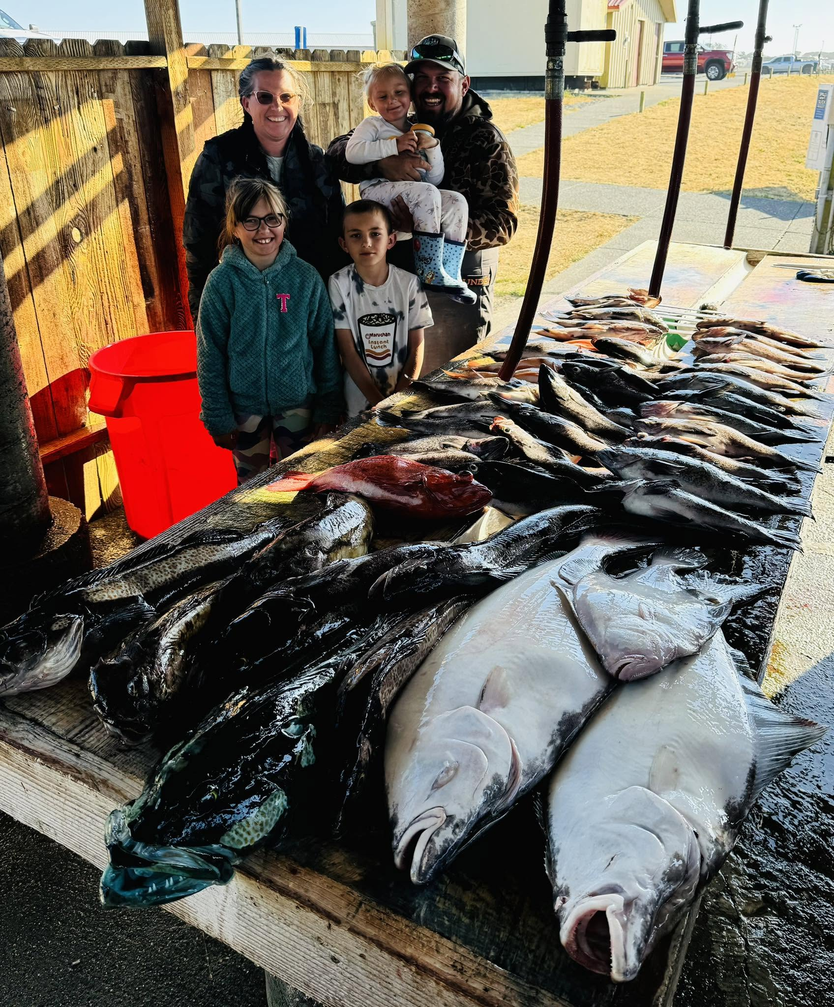 Gold Beach family gathered behind a dockside mixed catch