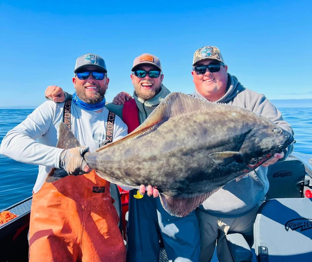 Three Gold Beach anglers displaying a Pacific halibut