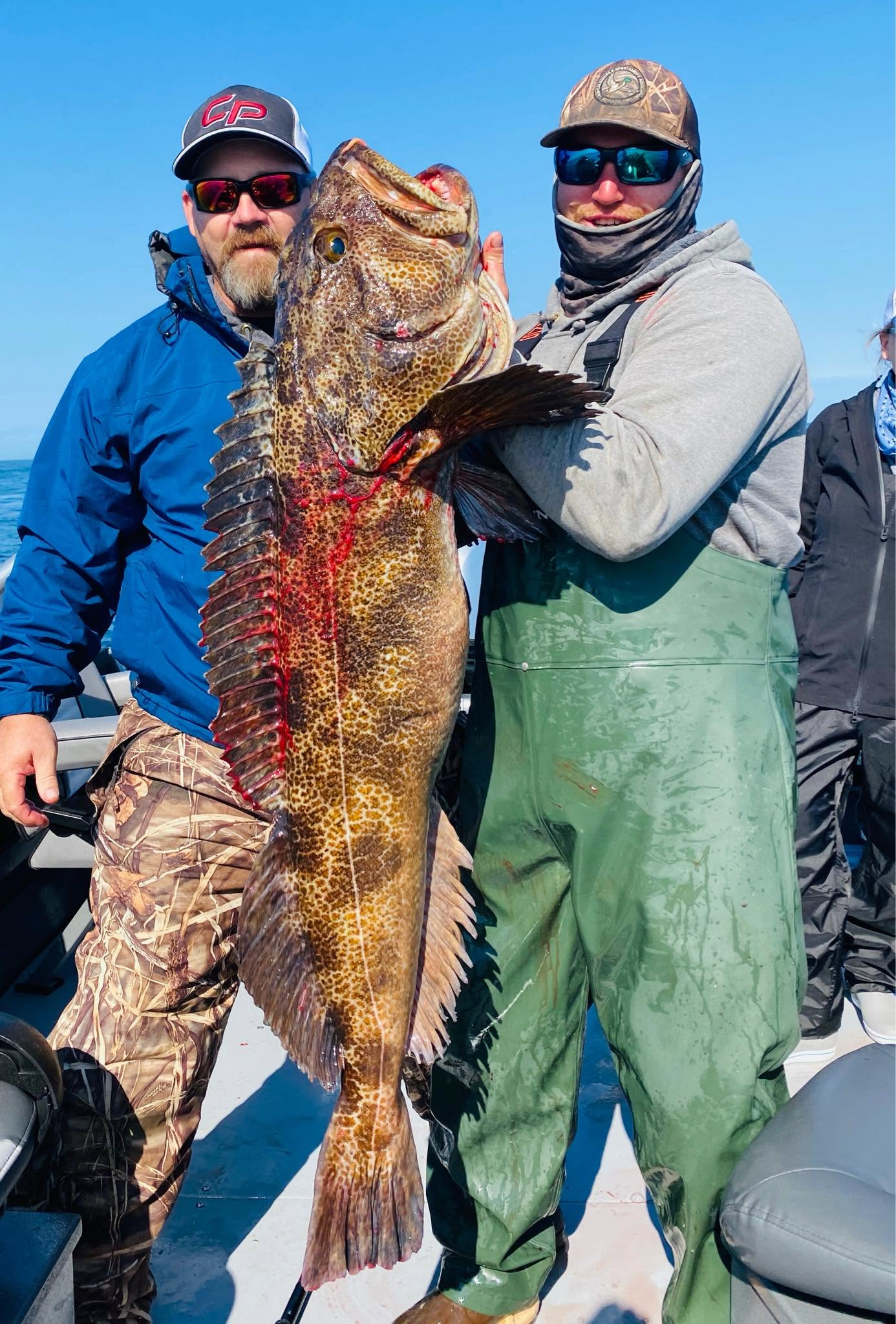 Two Gold Beach anglers holding a large Pacific lingcod