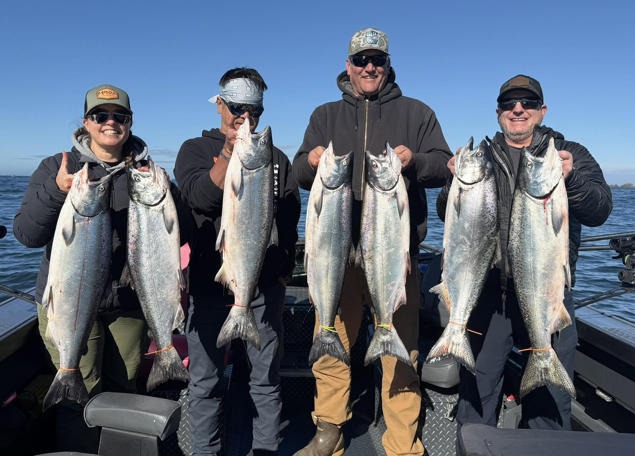 Four Gold Beach anglers smiling with a strong salmon catch