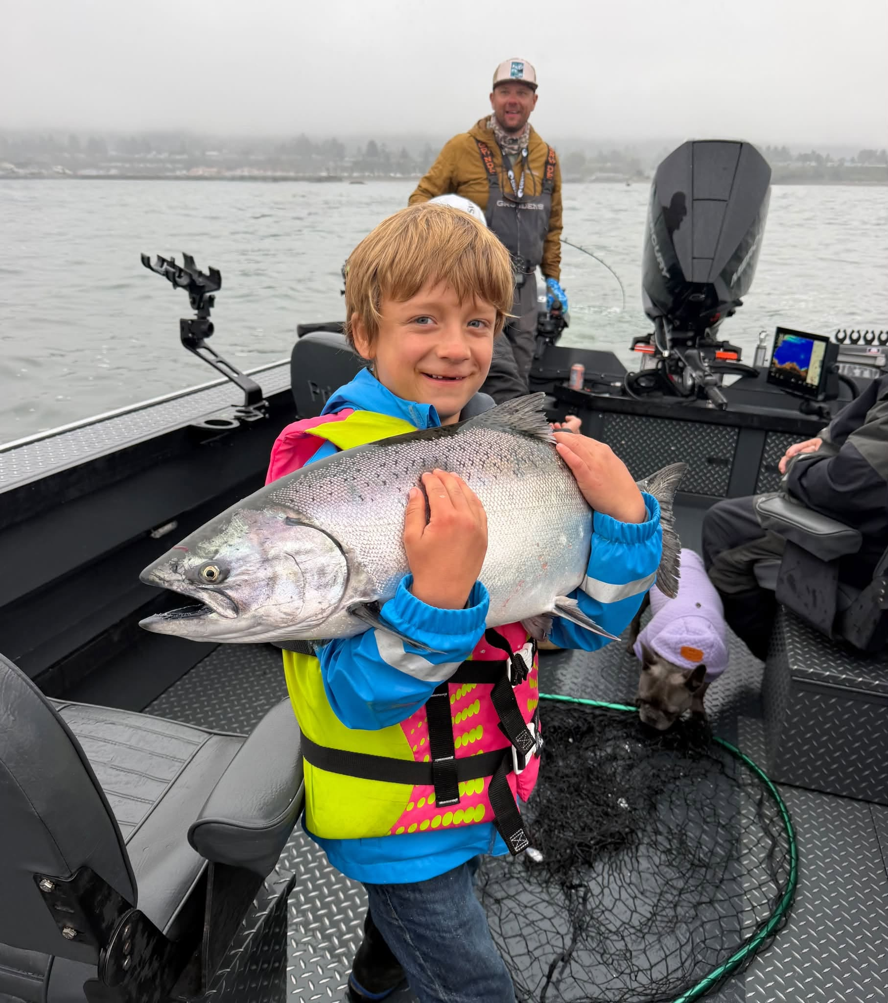 Young angler proudly holding a Gold Beach King salmon
