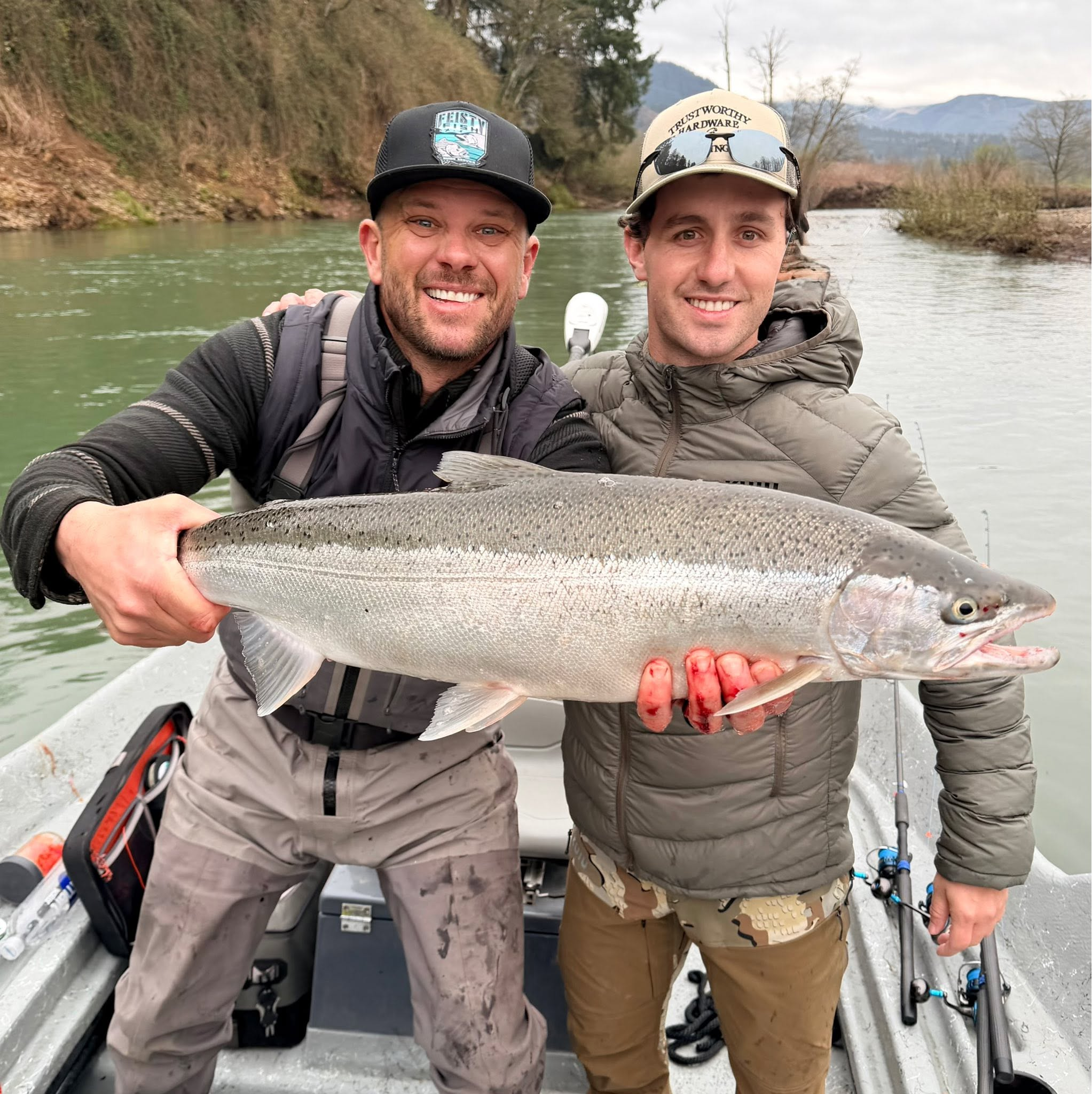 Scott Feist and a guest holding a winter steelhead on the river
